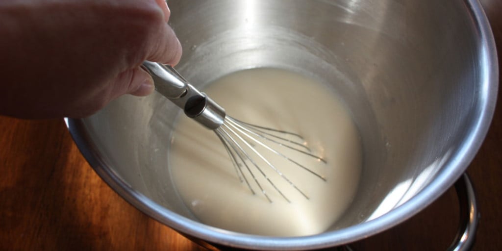 Yeast blooming in a metal mixing bowl.