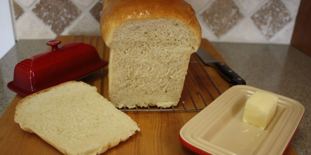 Homemade Sandwich Bread sliced on a wooden board.