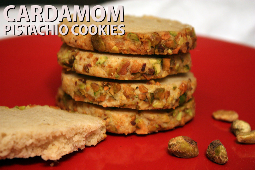 Cardamom  pistachio cookies stacked on a red plate.