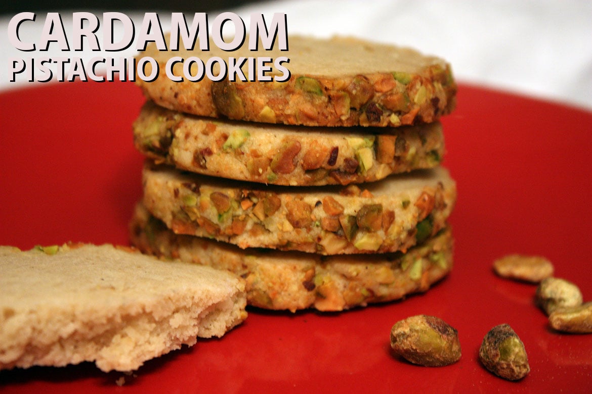 Cardamom pistachio cookies stacked on a red plate.