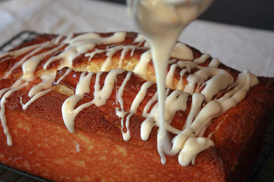 icing being drizzled over the Meyer Lemon Loaf 