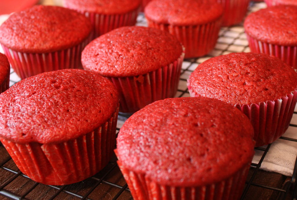 Unfrosted baked cupcakes on a wire rack.