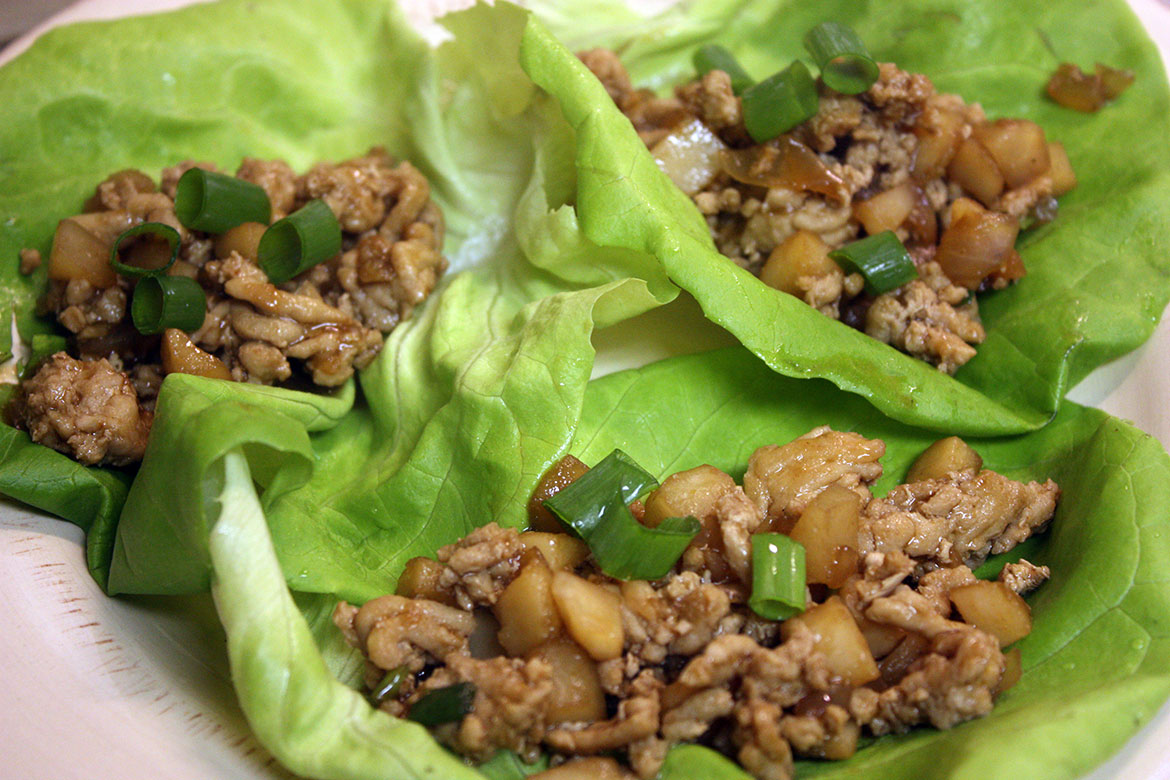 Chicken lettuce wraps on a white plate.
