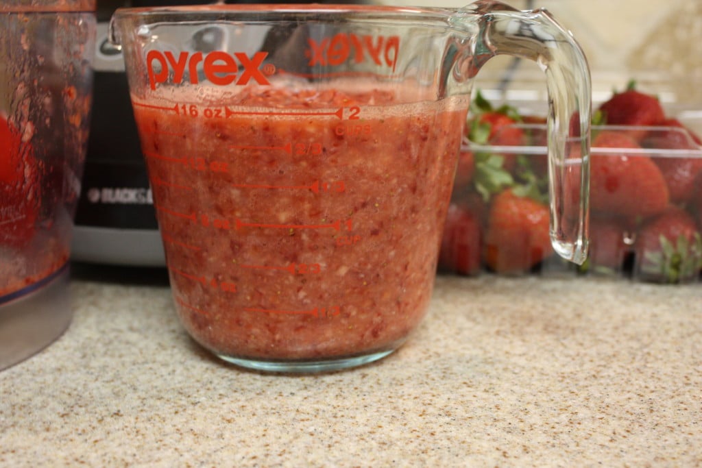 Fresh strawberry puree in a glass measuring cup.