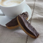 Espresso biscotti resting next to a latte.