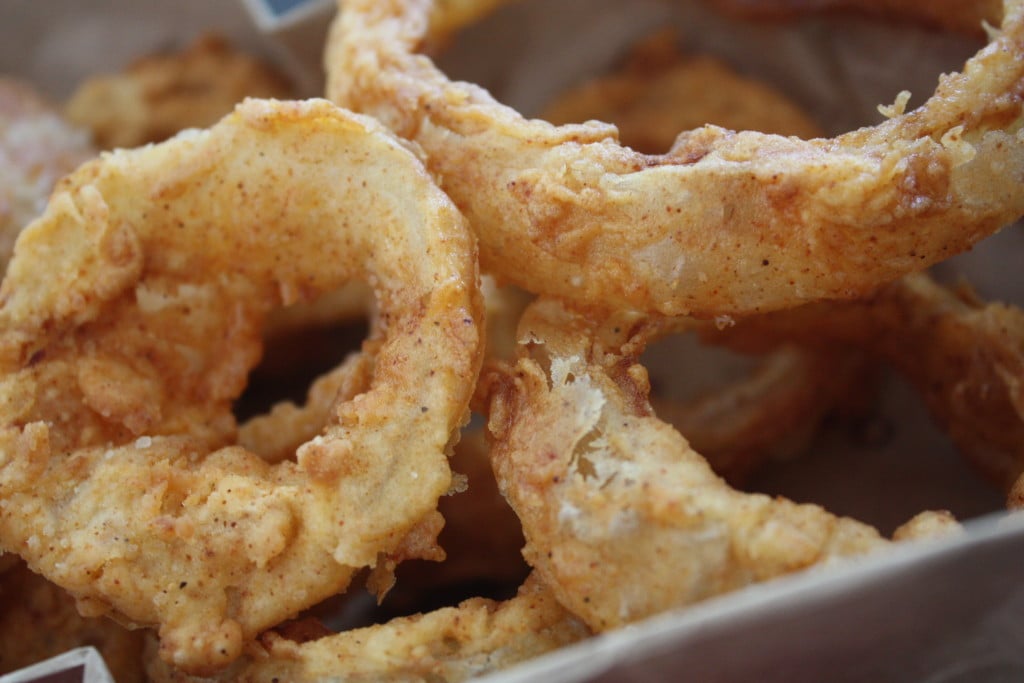 Beer battered onions rings in a basket.