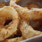 Beer battered onions rings in a basket.