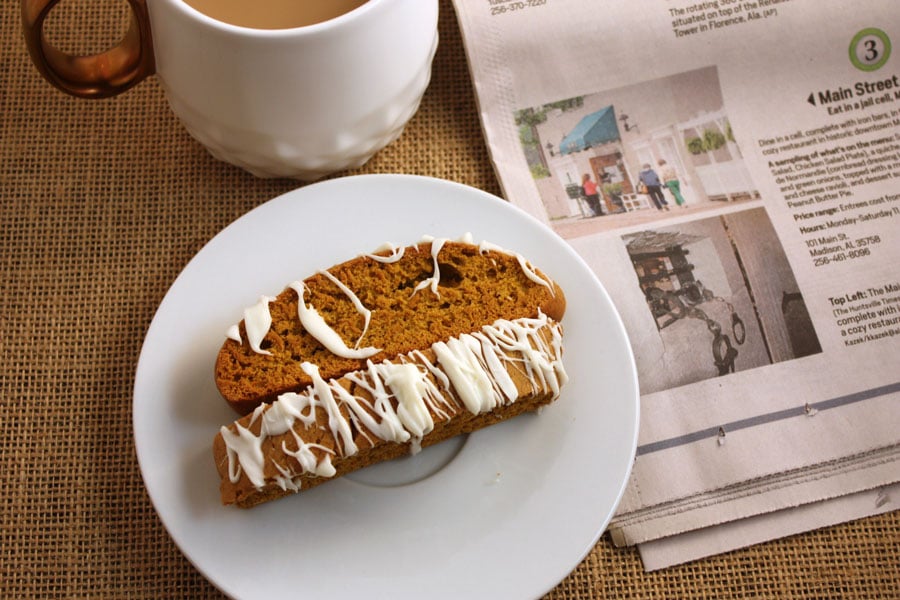 Pumpkin Spice Latte Biscotti - This biscotti on a white plate with coffee in the background..
