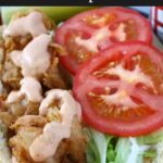 Fried shrimp po boy in a brown paper lined red basket.