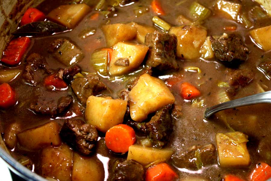 Beef stew in a blue dutch oven.