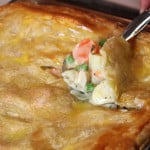 Chicken Pot Pie with the spoon just breaking through the crust.