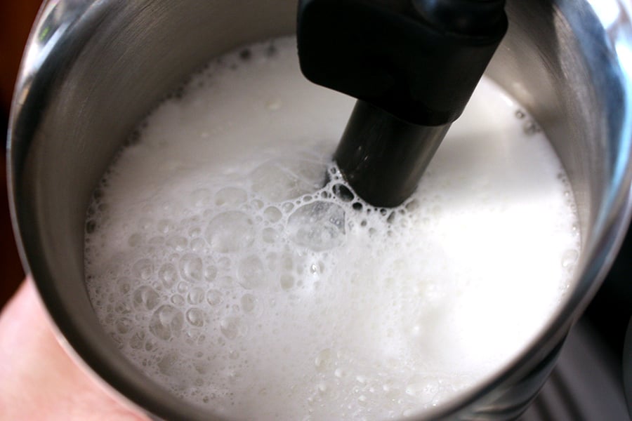 Holiday Spice Flat White - milk being steamed in a metal frothing container