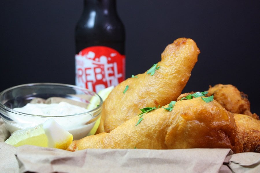 Beer Battered Fish in a basket with a beer in the background.