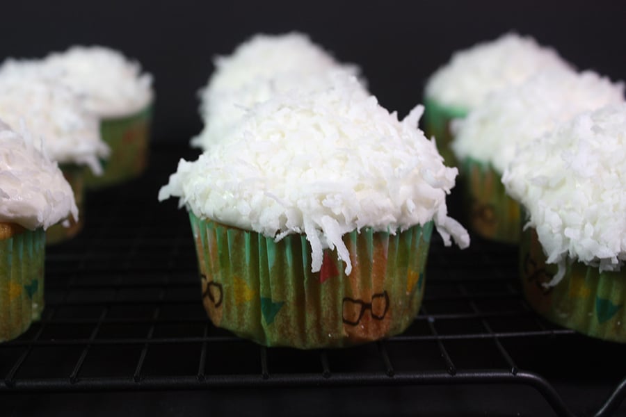 frosted Coconut cupcakes on a wire rack