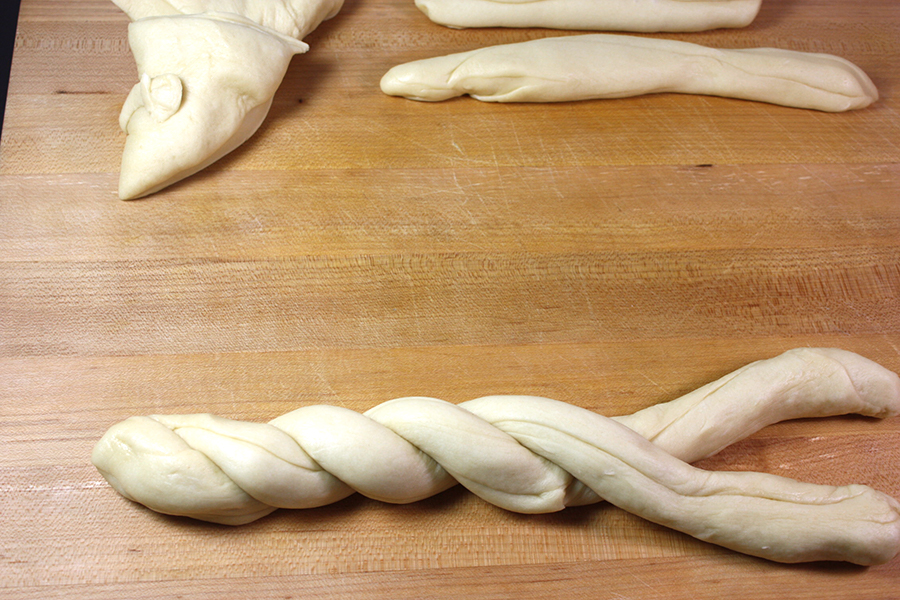 Dough shaping on a wooden cutting board.