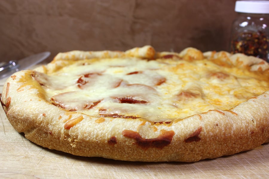 Slow cooker pizza resting on a cutting board.