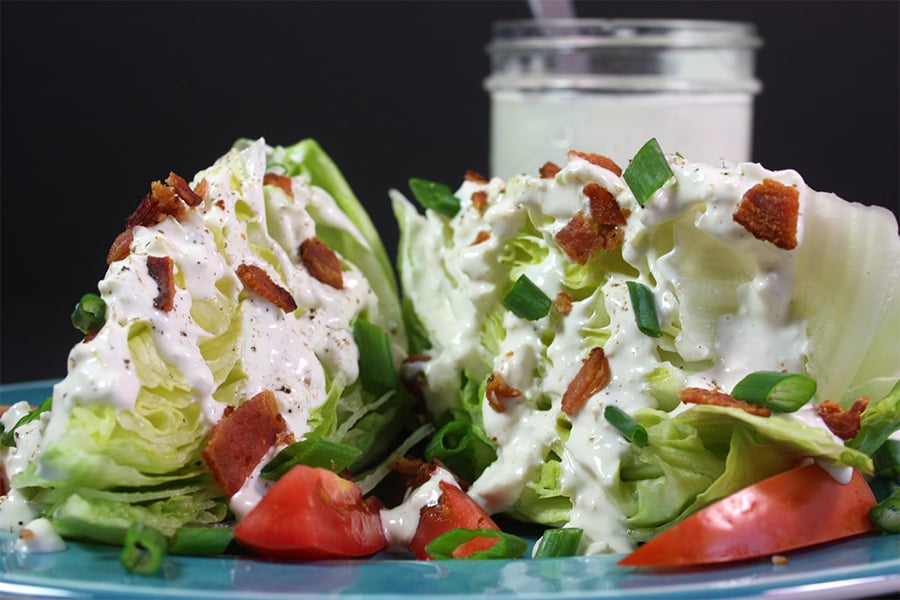 Blue cheese wedge salad on a blue plate.