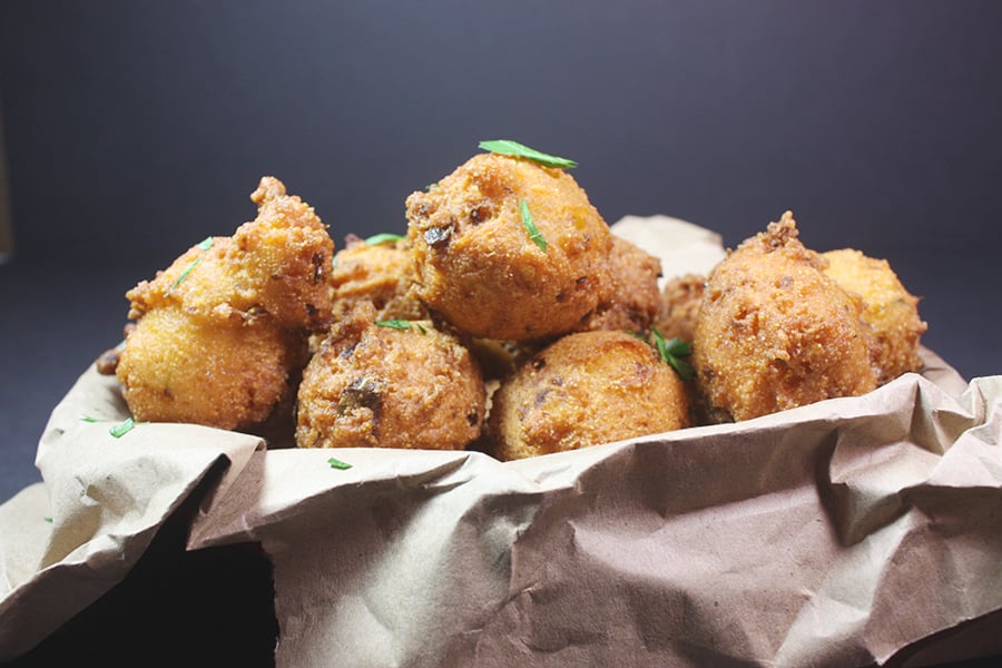 Jalapeno Hushpuppies in a basket lined with brown paper.