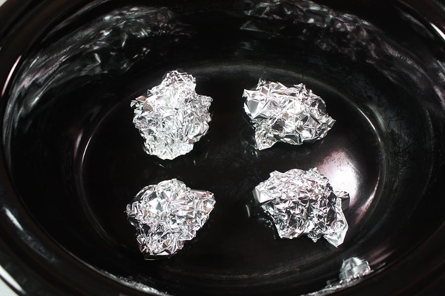 Small balls of aluminum foil in the crock of a slow cooker.