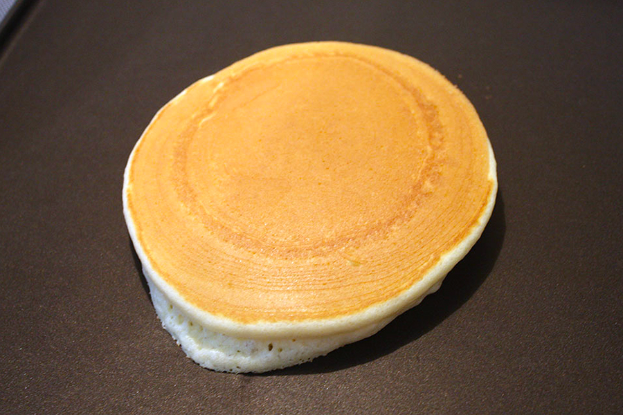 One pancake on a griddle pan.