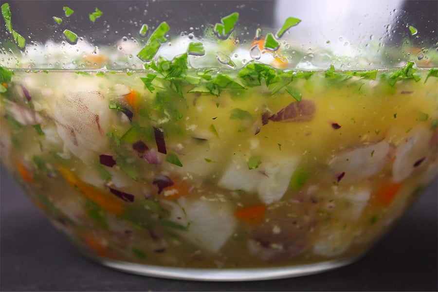 All the ingredients for ceviche in a glass mixing bowl.