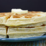 A stack of round waffles on a blue plate.