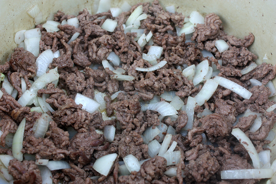 Ground beef and onion in a large dutch oven.