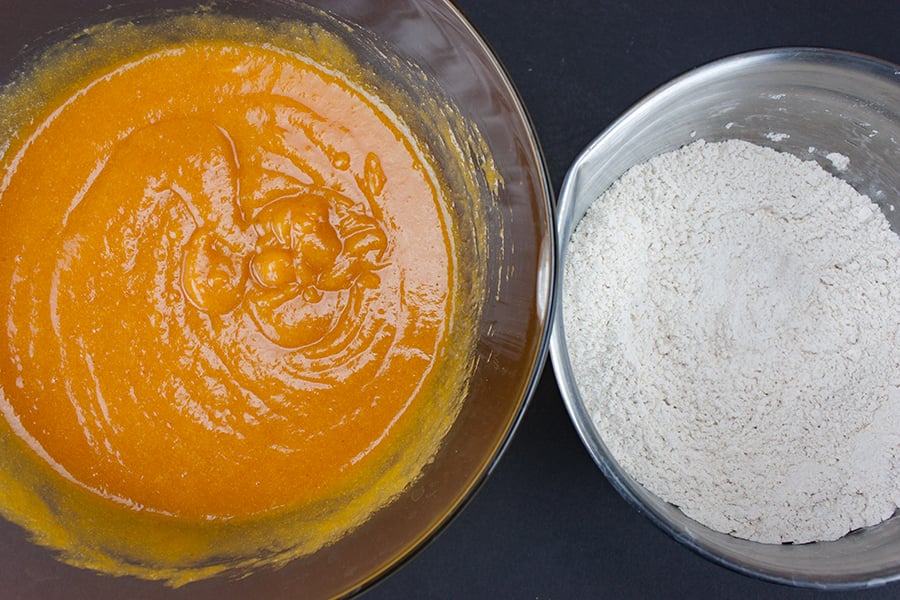 Bakery Style Pumpkin Muffins - wet ingredients combined in a glass bowl next to dry ingredients combined in a metal bowl