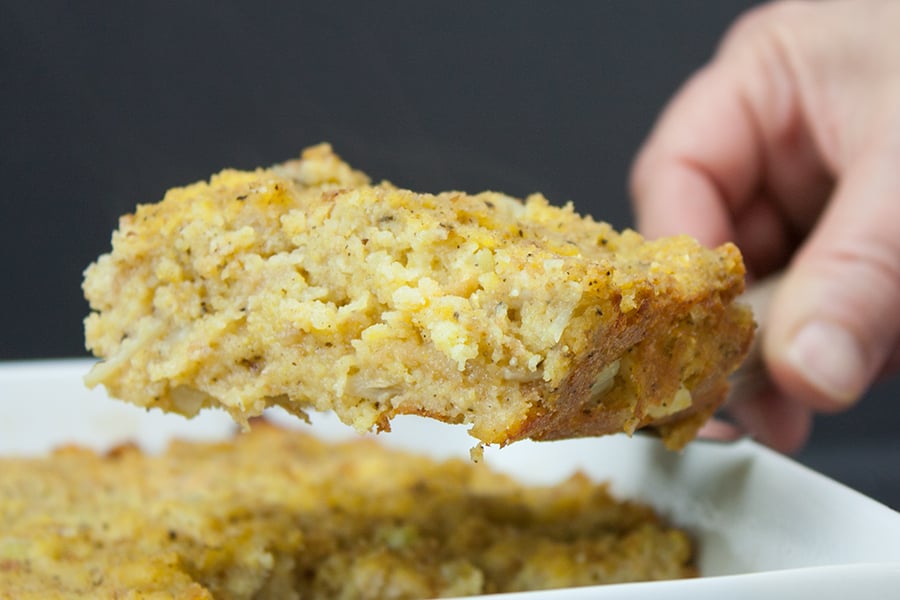 A serving of southern cornbread dressing lifted above the pan.