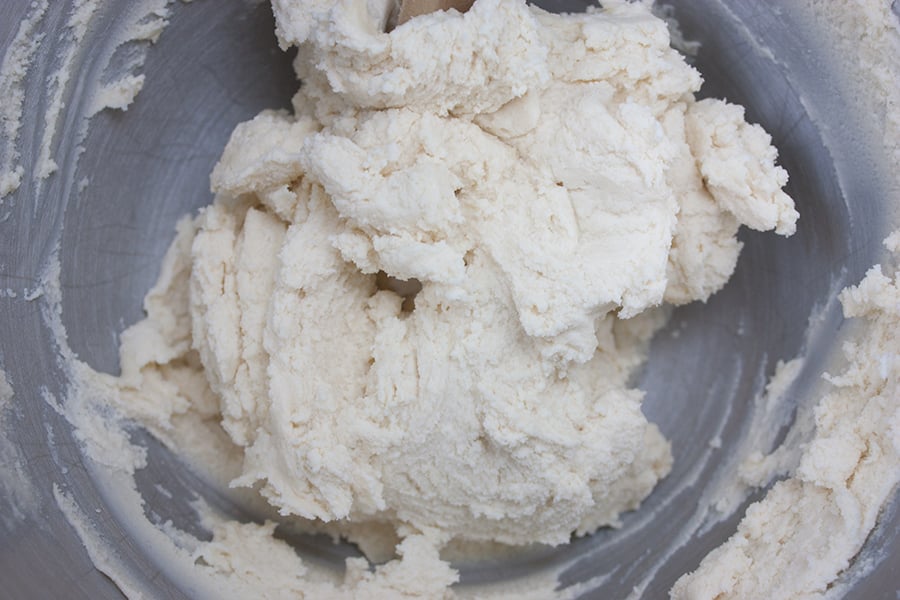 Cookie dough in a metal mixing bowl.