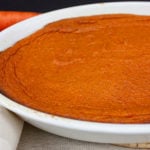 Carrot souffle in a white casserole dish.