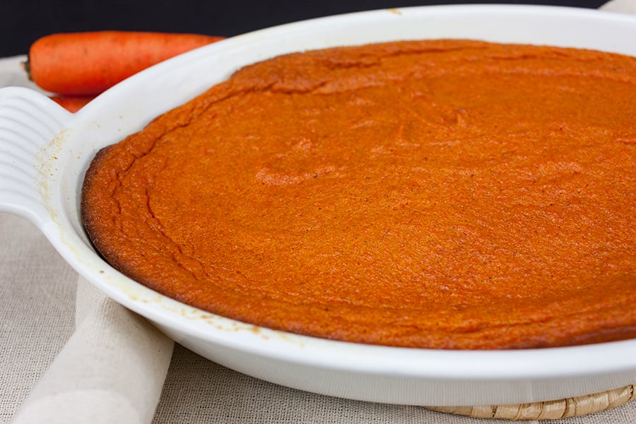 Carrot souffle in a white casserole dish.