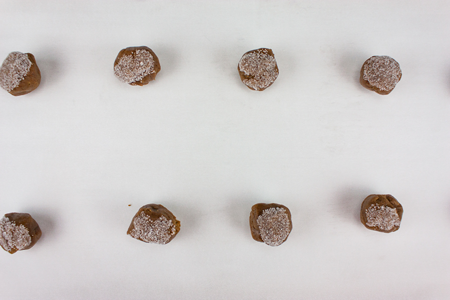 Dough balls rolled in sugar and placed on a parchment paper lined baking sheet.