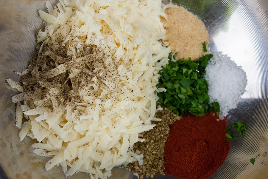 Parmesan cheese and spices in a metal bowl.