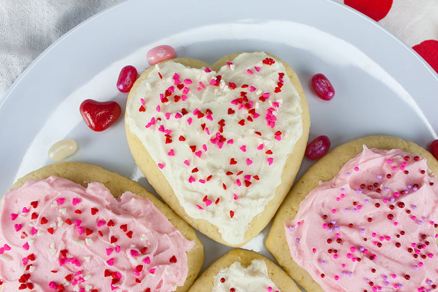 Heart shaped cookies garnished with sprinkles on a plate.
