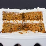 Best Homemade Carrot Cake on a cake serving platter with a wedge removed.