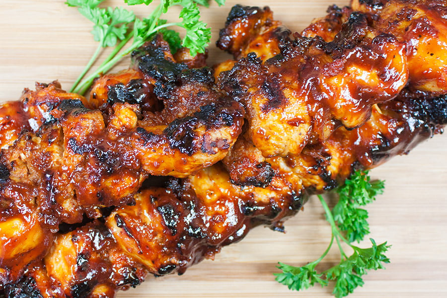 Bacon Paste BBQ Chicken Kebabs on a wooden cutting board