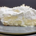 Homemade Coconut Cream Pie slice on a grey plate.