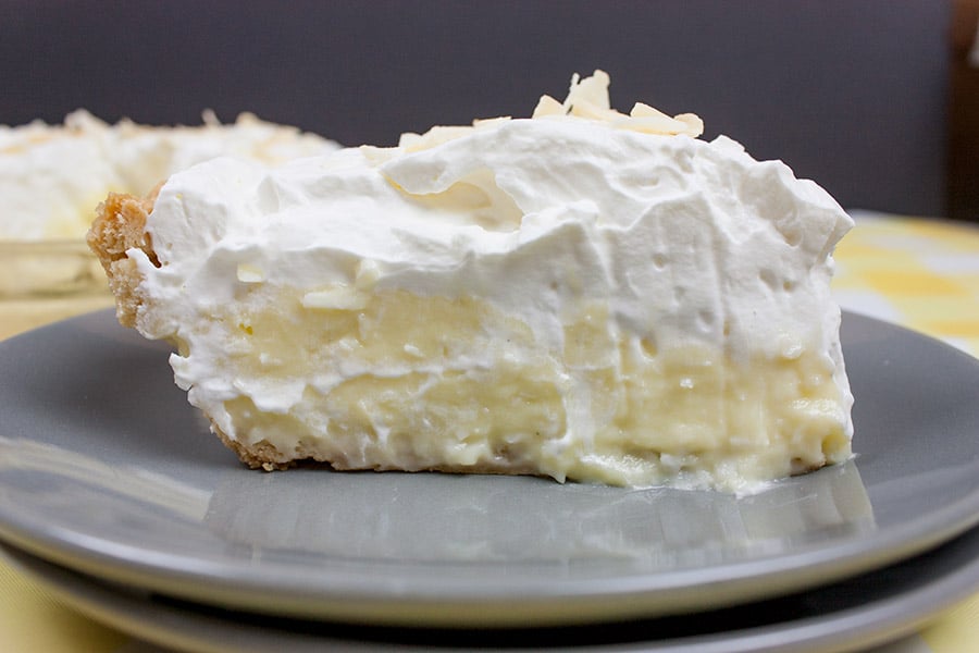 Homemade Coconut Cream Pie slice on a grey plate.