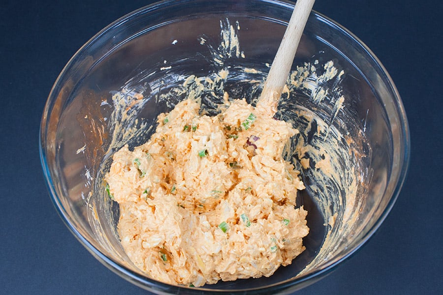 Buffalo Chicken Pinwheels ingredients mixed in a glass mixing bowl.