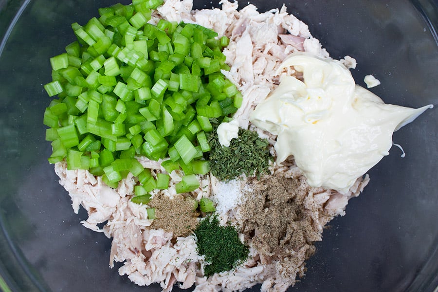 Savory Chicken Salad - shredded chicken, celery, mayonnaise, and spices in a glass mixing bowl
