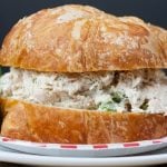 Savory Chicken Salad sandwich on a checkerboard paper plate with a celery garnish.