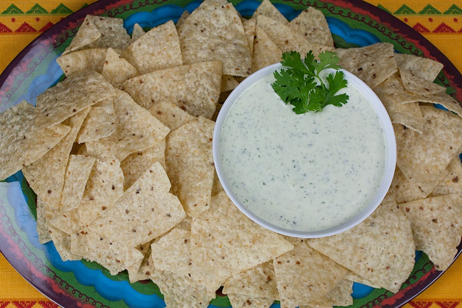 Creamy Jalapeno Cilantro Dip in a white bowl surrounded by tortilla chips