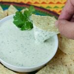 Creamy Jalapeno Cilantro Dip in a serving bowl surrounded with tortilla chips.