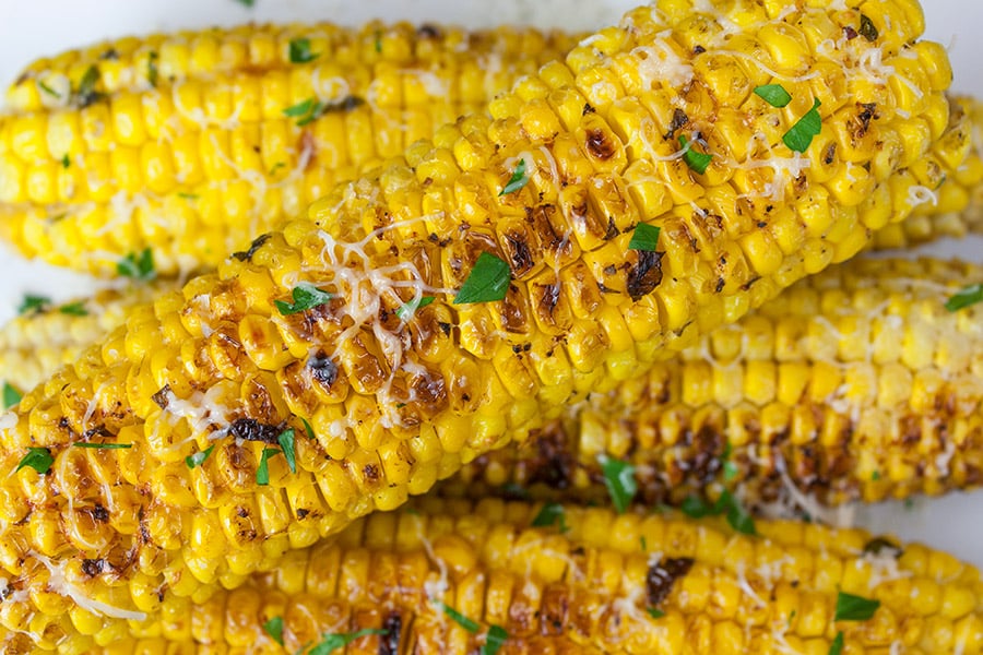 Grilled Parmesan Corn On The Cob stacked on top of each other.