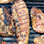 Best Ever Grilled Chicken Marinade on chicken grilling on a Weber grill.