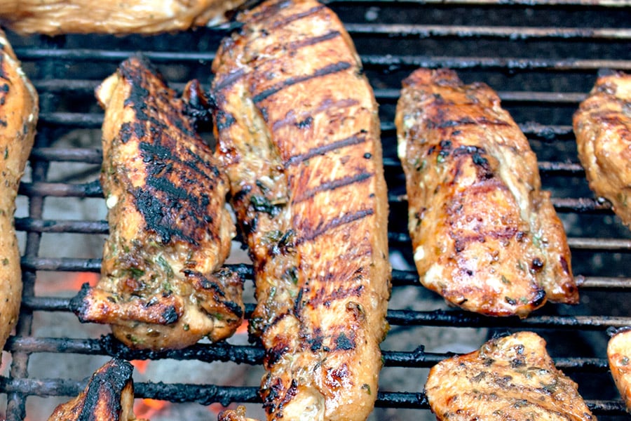 Best Ever Grilled Chicken Marinade on chicken grilling on a Weber grill.