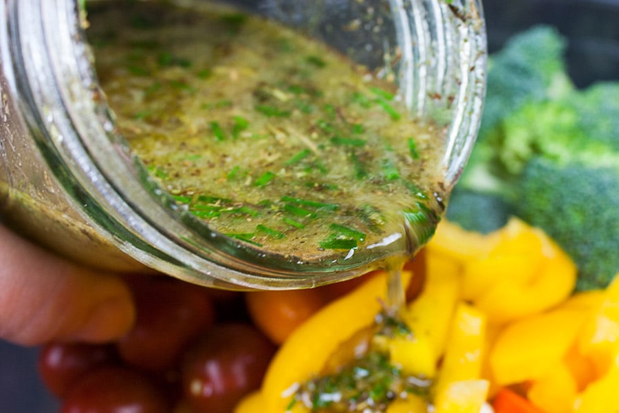 Marinated Fresh Vegetable Salad marinade being poured over the vegetables
