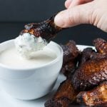 Alabama White BBQ Sauce being used on a smoked chicken wing.