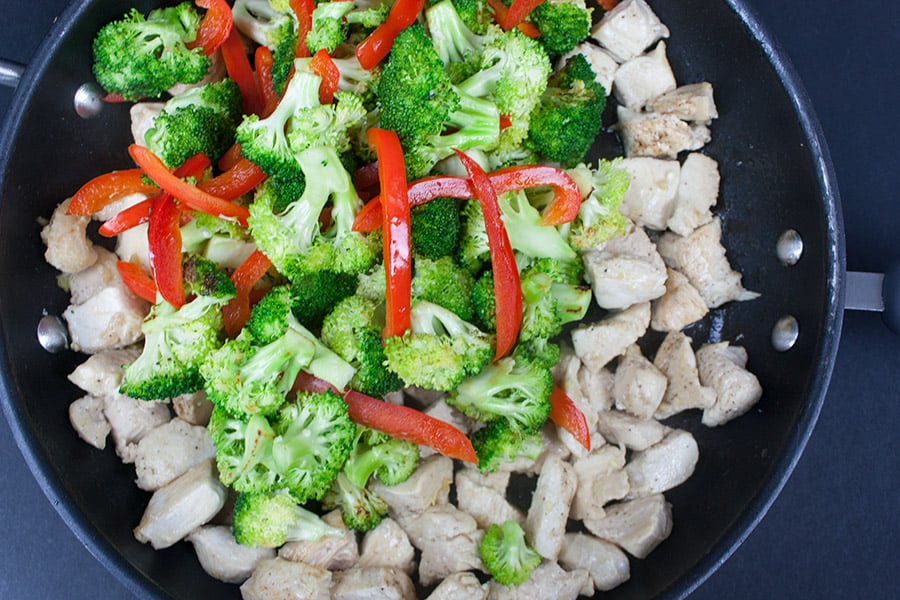 Easy Chicken and Broccoli Stir Fry - chicken, broccoli, and red bell pepper in a skillet